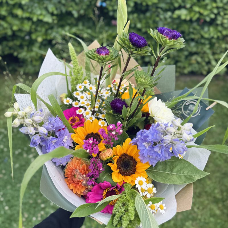 Luxe boeket met oranje en paarse bloemen voor een feestelijke gelegenheid.