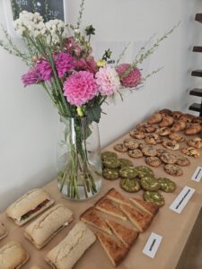 grote vaas met kleuren wit en roze bij een verjaardag met allerlei eten erbij